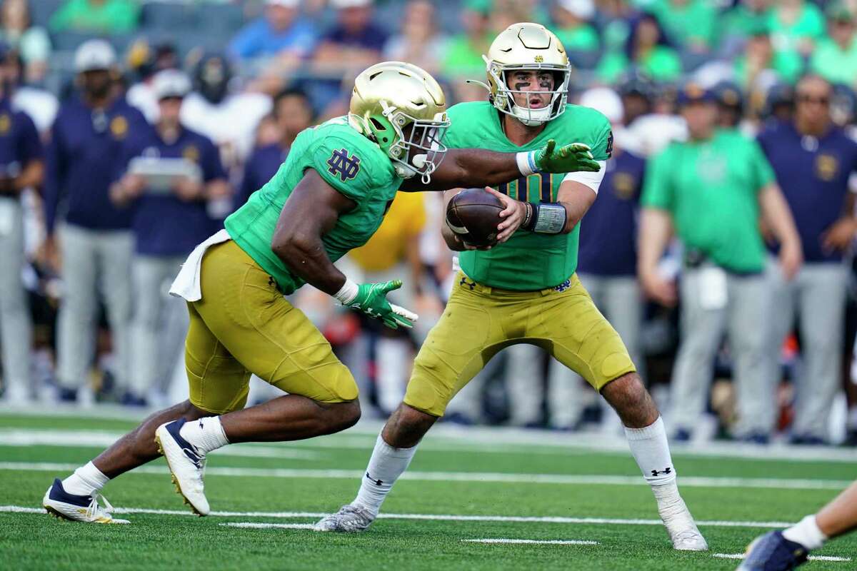 Notre Dame running back Audric Estime takes the hand off from quarterback Drew Pyne on his way to a touchdown during the second half of an NCAA college football game in South Bend, Ind., Saturday, Sept. 17, 2022. Notre Dame defeated California 24-17.