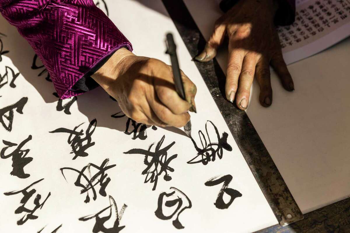 Calligraphy artist Terry Luk writes with a traditional ink brush during the Autumn Moon Festival.