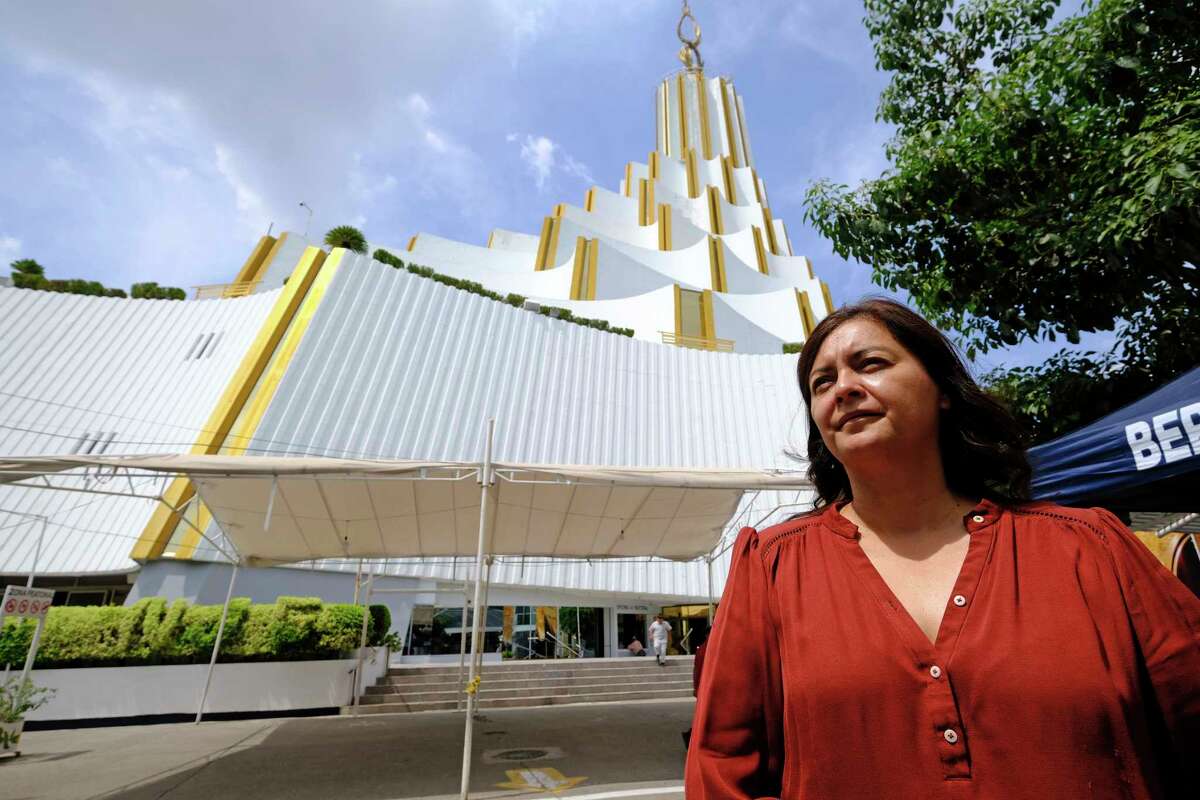Congregant Sara Pozos stands outside the La Luz del Mundo, Spanish for The Light of the World, church’s home base, during an interview in the Hermosa Provincia neighborhood of Guadalajara, Mexico, Saturday, Aug. 13, 2022. Bethlehem and Nazareth are among the names of roads converging on the white temple that locals call “the cake,” for its white tiers that diminish in size as they rise upward.