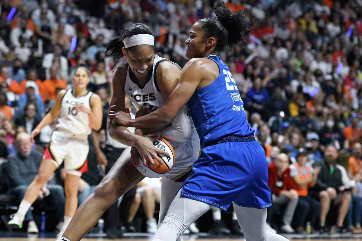 Las Vegas Aces' A'ja Wilson, left, is pressured by Connecticut Sun's Alyssa Thomas, right, during the first half in Game 4 of a WNBA basketball final playoff series, Sunday, Sept. 18, 2022, in Uncasville, Conn.