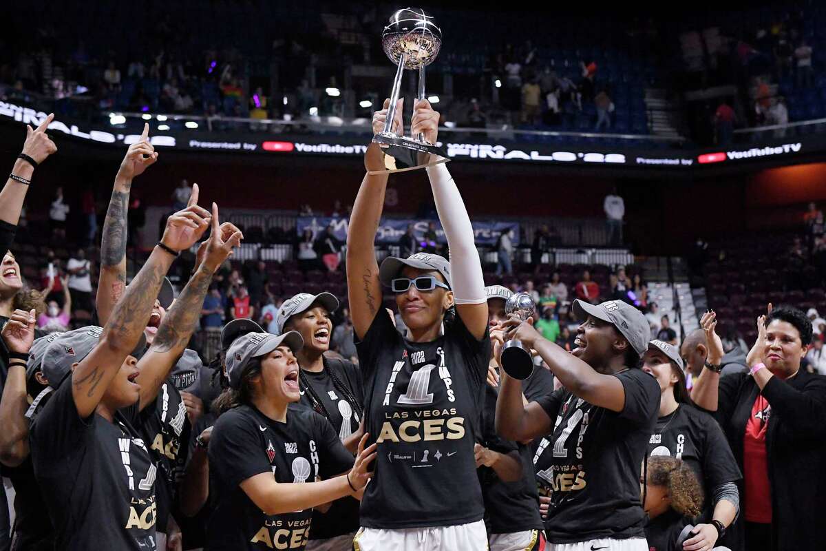 Las Vegas Aces' A'ja Wilson holds up the championship trophy as she celebrates with her team their win in the WNBA basketball finals against the Connecticut Sun, Sunday, Sept. 18, 2022, in Uncasville, Conn.