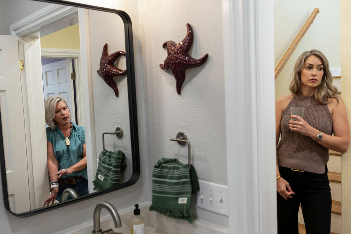 Homeowner Melanie Tucker, left, talks about bathroom renovations with designer Monica Beyer, right, of New Generation Kitchen & Bath in Tucker's recently renovated downstairs bathroom.