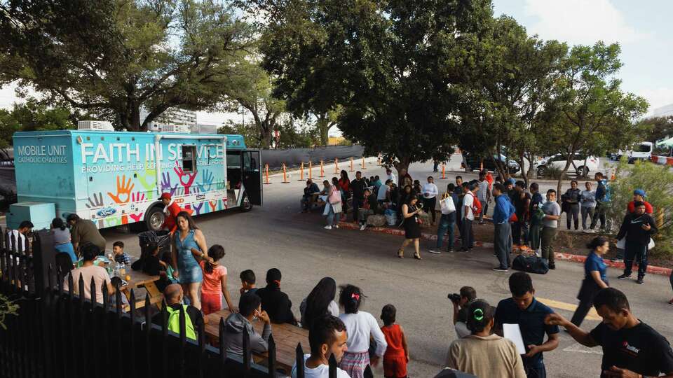 Migrants wait outside San Antonio’s Migrant Resource Center to receive food donations from Catholic Charities.