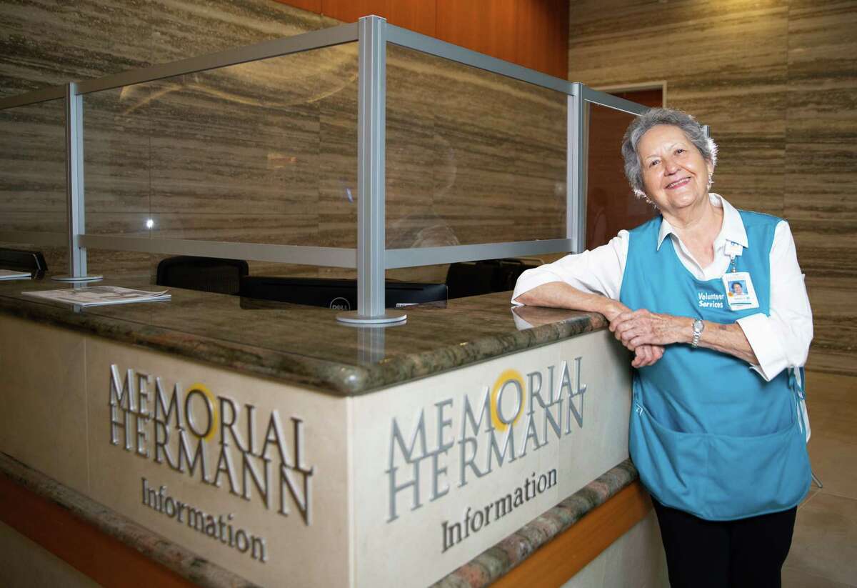 Memorial Hermann Memorial City Hospital volunteer greeter Nancy Kadala, 84, poses for a photograph Monday, Aug. 29, 2022, at information desk in Houston. Kadala, 84, has been volunteering for nearly 30 years.