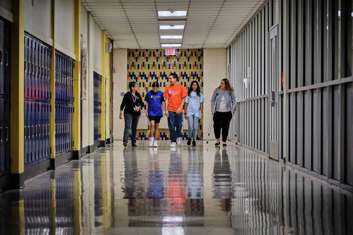 Lisa Descant, CEO at Communities in Schools of Houston, right, and volunteer Lourdes Jimenez, left, walk through Spring Forest Middle School with students Karlat, Angel, left, Heidi, who have benefited from the organization's support.