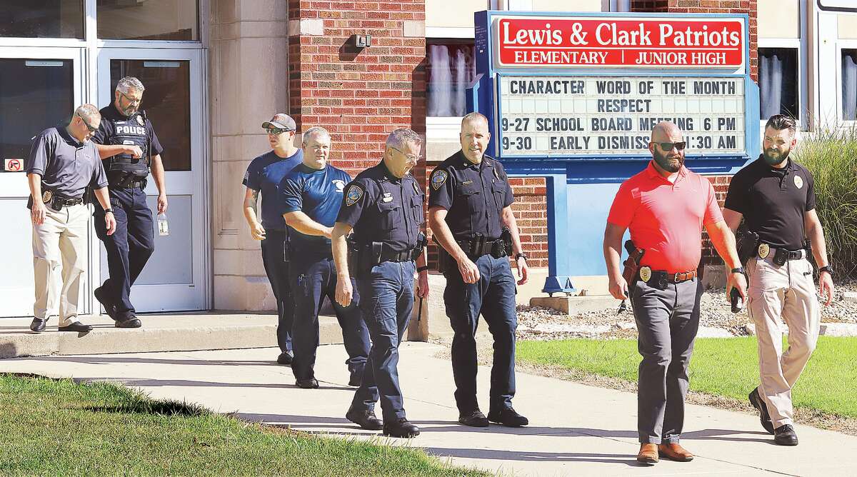 John Badman|The Telegraph Wood River police and firefighters walk out of Lewis and Clark elementary and junior high schools Tuesday after concluding a lock down drill.