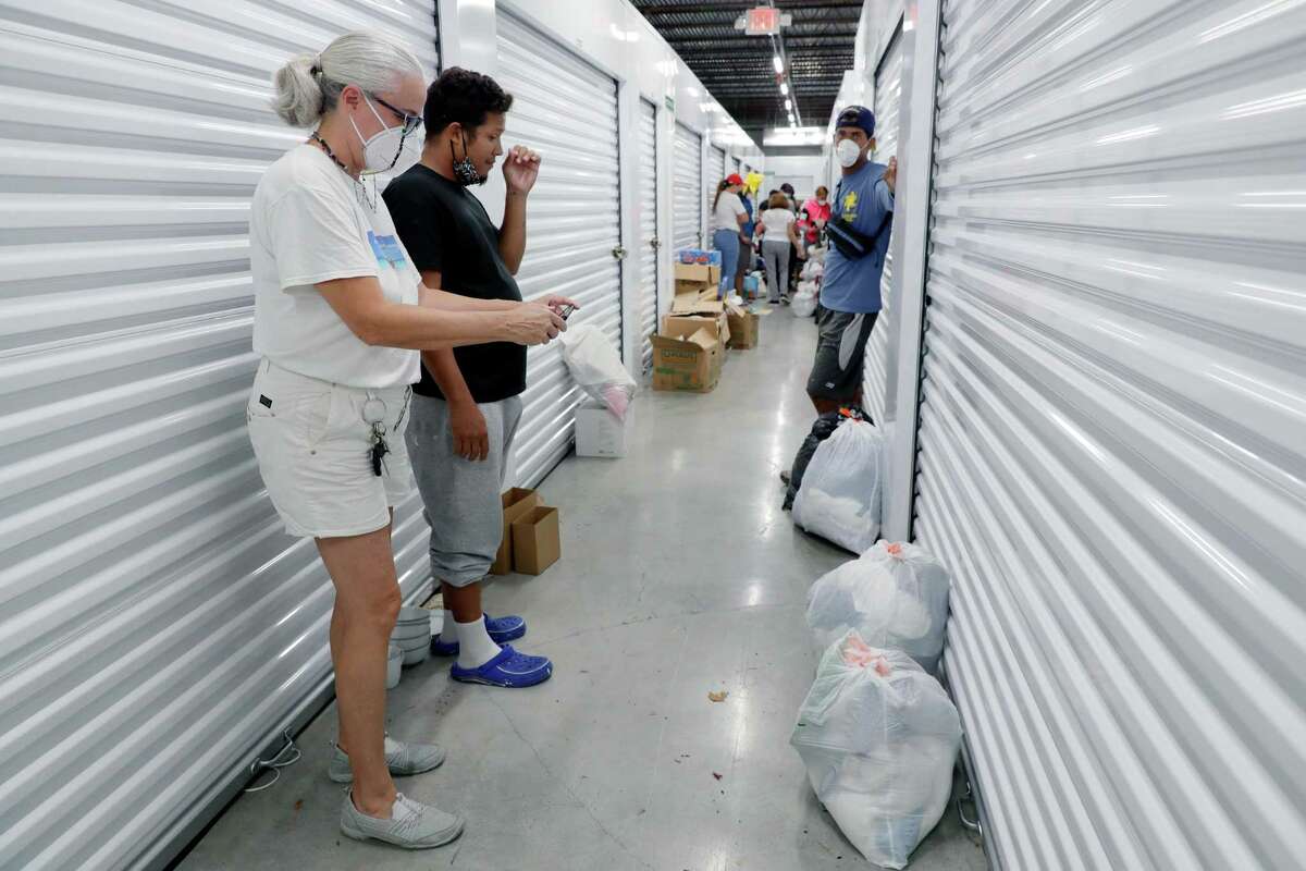 Diana Mendt, left, founder of Acción Social — Venezuela, helps Venezuelan immigrants select donated clothes and household items from the group’s storage units.
