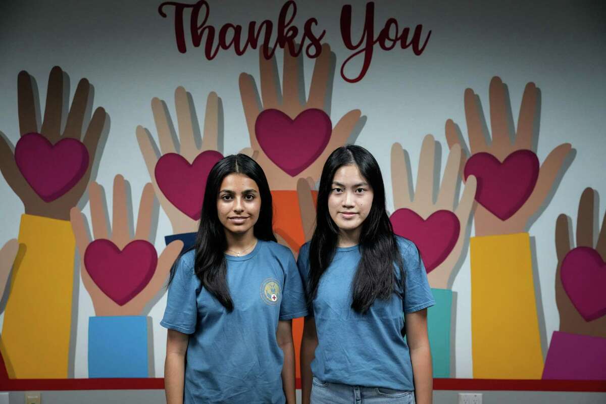 Sara Khokhar, left, and Emily Wang, both 17, pose for a portrait Monday, Aug. 15, 2022, at the Jesse H. Jones American Red Cross Building in Houston. The pair are volunteers with the Red Cross who have an interest in conflict resolution and the rules of warfare. “Even if it isn’t an immediate solution, it can bring solution,” Khokhar said of their work.