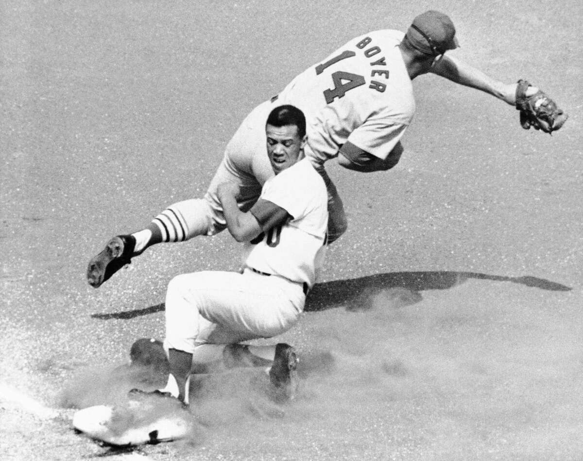 FILE - Los Angeles Dodgers' Maury Wills is safe at third as St. Louis Cardinals' Ken Boyer takes the throw during the first inning of a baseball game in Los Angeles, Sept. 26, 1965. Maury Wills, who helped the Los Angeles Dodgers win three World Series titles with his base-stealing prowess, has died. The team says Wills died Monday night, Sept. 19, 2022, in Sedona, Ariz. He was 89. (AP Photo/FW)