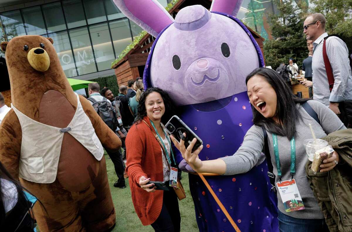 Nora Chao, right, and Maria Garzon, left, take a photo with Genie the Rabbit and Codey the Bear, two of the Salesforce mascots, during the Dreamforce 2022 conference in San Francisco, Calif., on Tuesday, September 20, 2022. Dreamforce 2022 is the biggest conference in San Francisco since the pandemic started.
