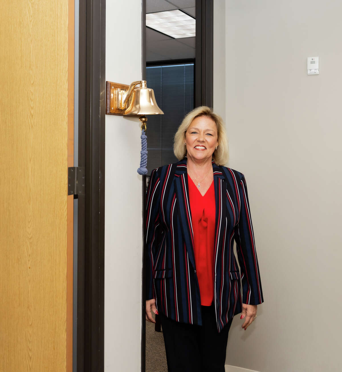 President of Better World Properties Terri Clifton stands by a bell her office in Houston, TX, September 21, 2022.