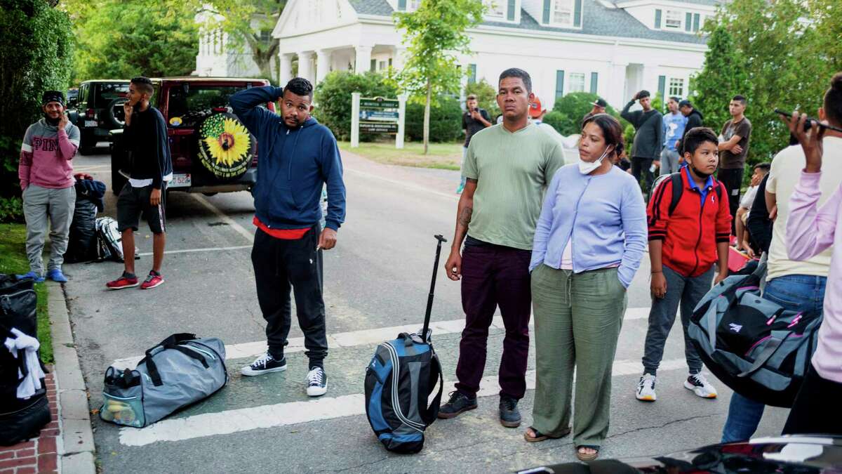 Migrants, who arrived on a flight sent by Florida Gov. Ron DeSantis, gather with their belongings outside St. Andrews Episcopal Church, Wednesday Sept. 14, 2022, in Edgartown, Mass., on Martha's Vineyard. A Texas sheriff on Monday, Sept. 19 opened an investigation into two flights of migrants sent to Martha's Vineyard by DeSantis, but did not say what laws may have been broken in putting 48 Venezuelans on private planes last week from San Antonio.