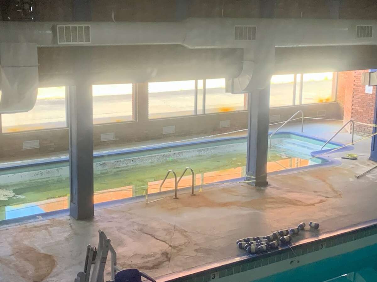 Stagnant water in Plaza Valley Hotel swimming pools, with green slime covering the surfaces.