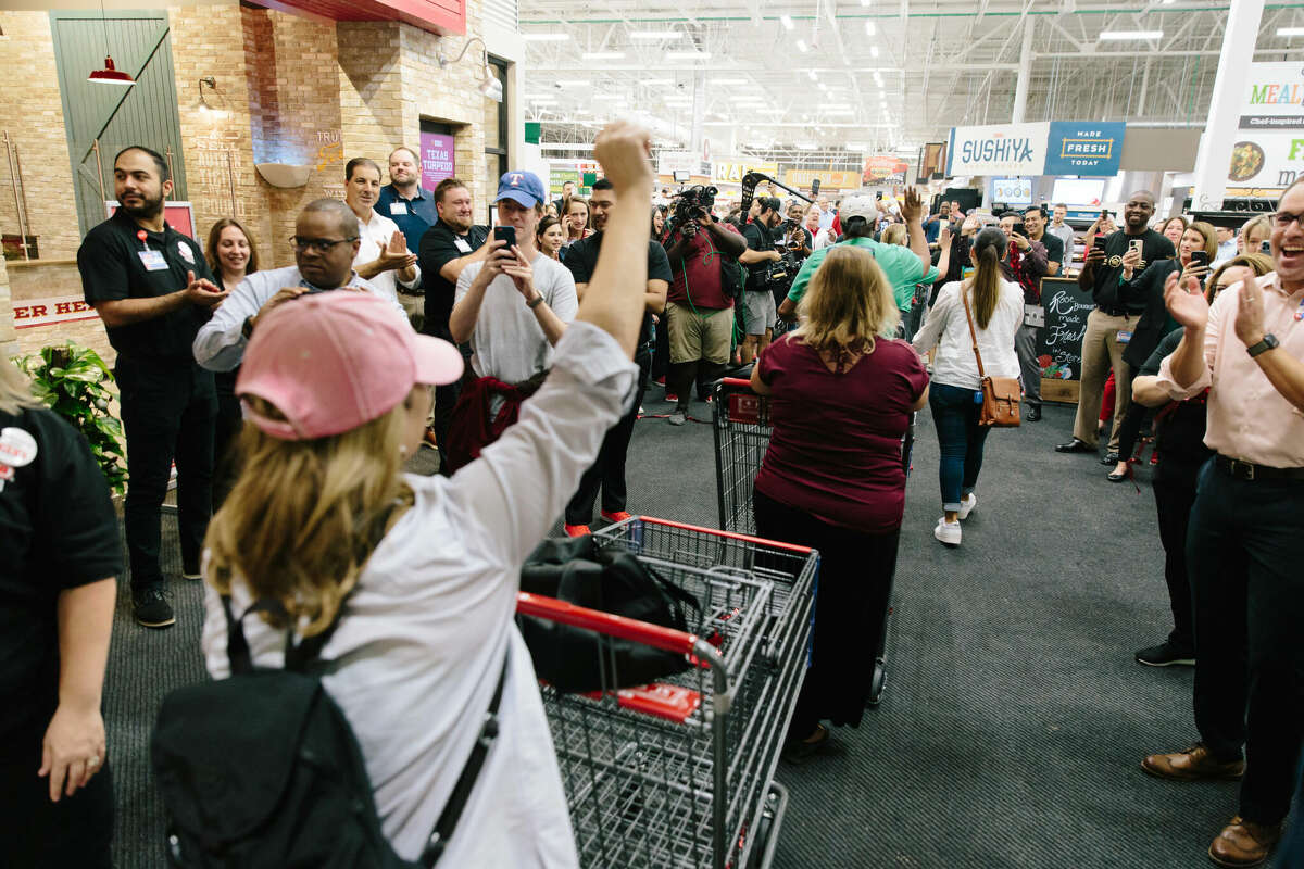 Some of the first customers raise a fist as they enter the store.