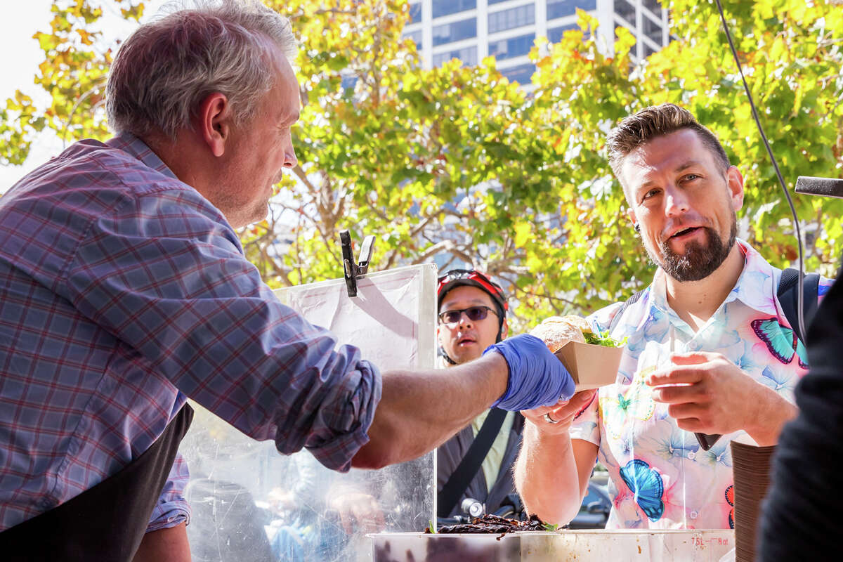 Thomas Odermatt handing a porchetta sandwich to a customer at the Roli Roti food truck at the Ferry Building in San Francisco, Calif. on Sept.
/p
p20, 2022.
