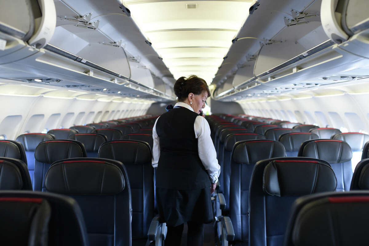 American Airlines longest-serving flight attendant, Bette Nash, checks the passenger seats in December 2017.