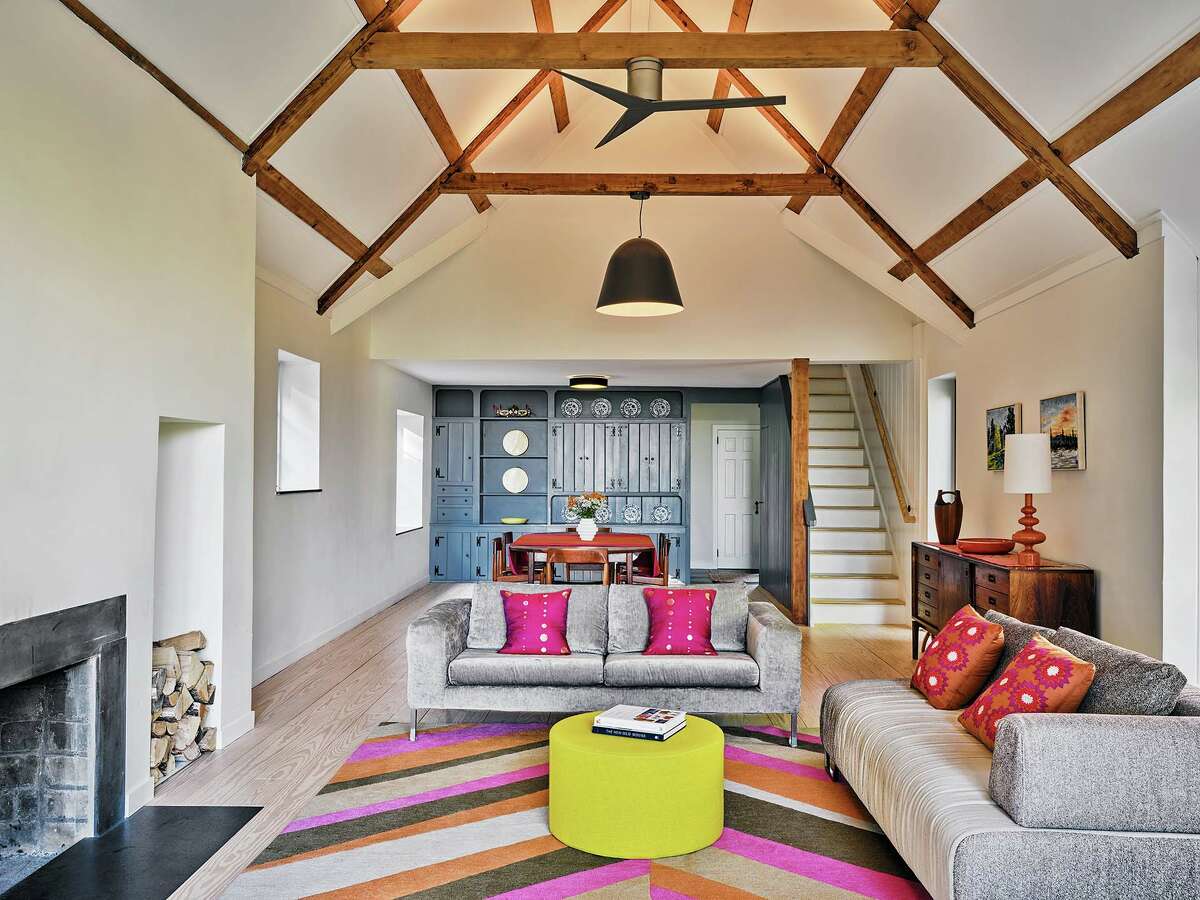 This living room (one of two) is another example of mixing old and new, with country-style built-ins and wooden ceiling beams playing with vibrant fabrics.