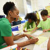 Third grade teacher Patrice Moore wears green along with her students Mary Yohannes, second from left, Jay Shaw, third from left, and Davis Wroblewski for "Wear Green Wednesday" during Start with Hello Week at Hart Magnet Elementary School in Stamford, Conn. Wednesday, Sept. 21, 2022. Hart Elementary celebrated Start with Hello Week along nearly 4,000 schools across the country to teach students actions to "minimize social isolation, empathize with others, and create a more inclusive and connected school culture." The Sandy Hook Promise program encourages students to reach out help students who may feel lonely.