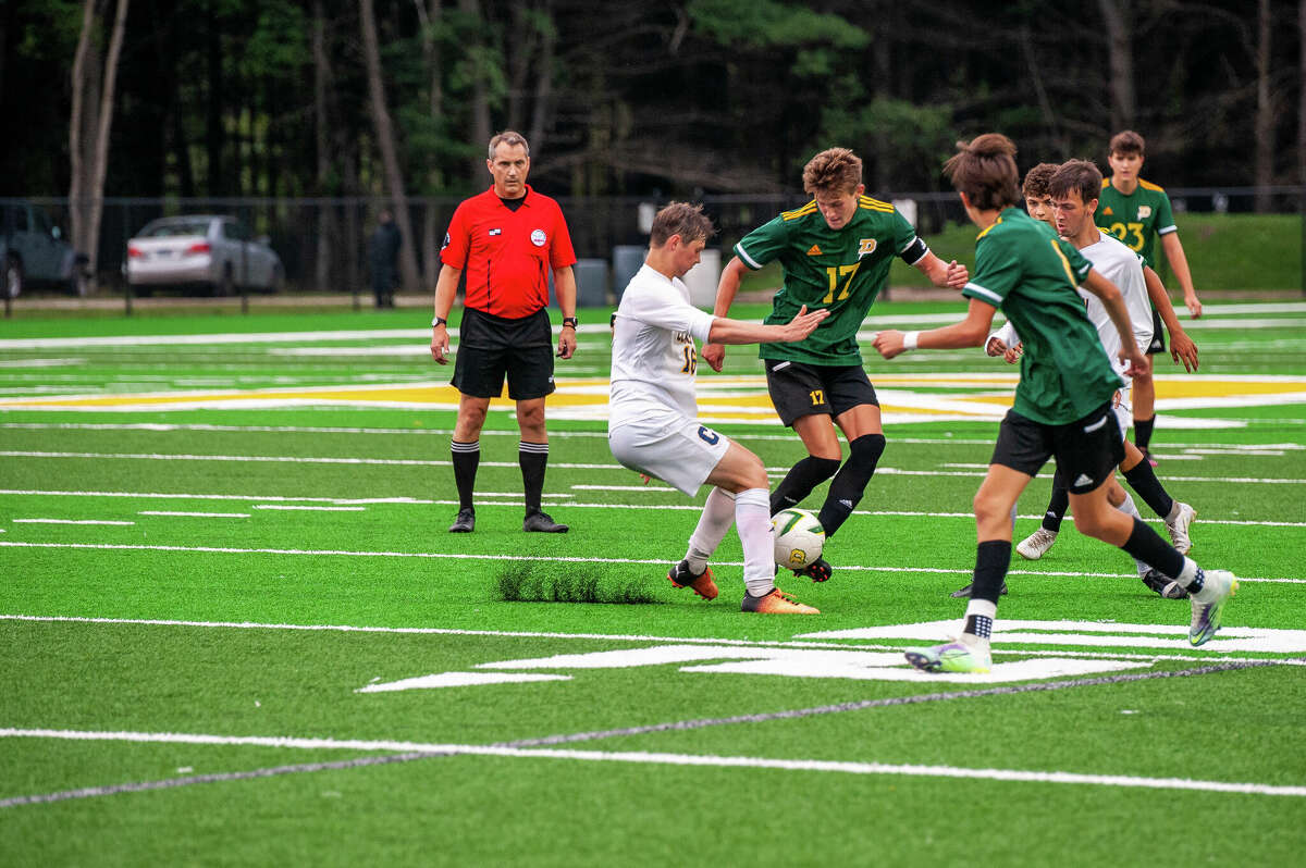 Dow High's Isaac Skinner (17) fights for possession during a game against Clarkston earlier this season. Skinner had two goals and two assists in the Chargers' 5-1 win over Saginaw Heritage on Wednesday, Sept. 21, 2022.