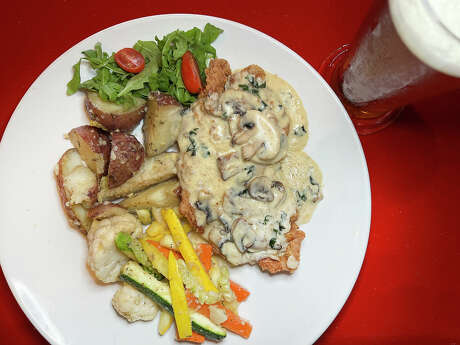 German pork schnitzel comes with vegetables and mashed potatoes at Europa Restaurant &amp; Bar on Jones Maltsberger Road in San Antonio. Mushroom sauce can be added for an extra charge. Beer options include Pilsner Urquell from the Czech Republic. 