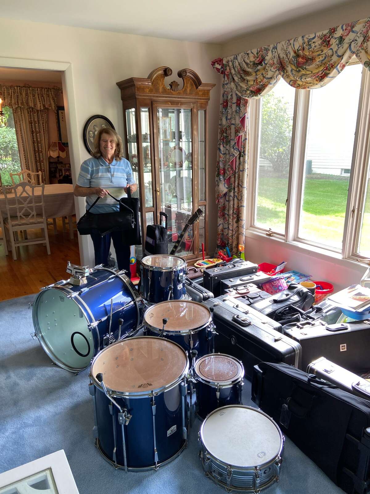 Jill Rifkin, who is in charge of Instruments for Students, stands in her living room surrounded by donations. Last fall, the program began partnering with local organizations for weekend drives to collect musical instruments for underprivileged students across the Capital Region. (Courtesy of Jill Rifkin)