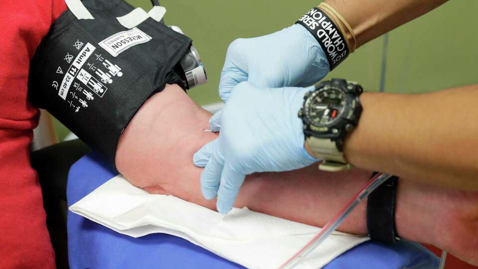 A needle is inserted into the arm of Lonnie Cox for his 100th gallon of blood donation at the Champions Neighborhood Donation Center Friday, Sept. 9, 2022 in Houston, TX.