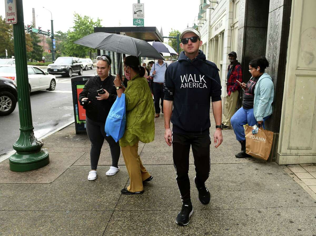 Isaiah Shields of Utah walks up Chapel Street on Sept. 22, 2022, during a stop in New Haven on his walk from the western-most point in Washington to the eastern-most point in Maine.