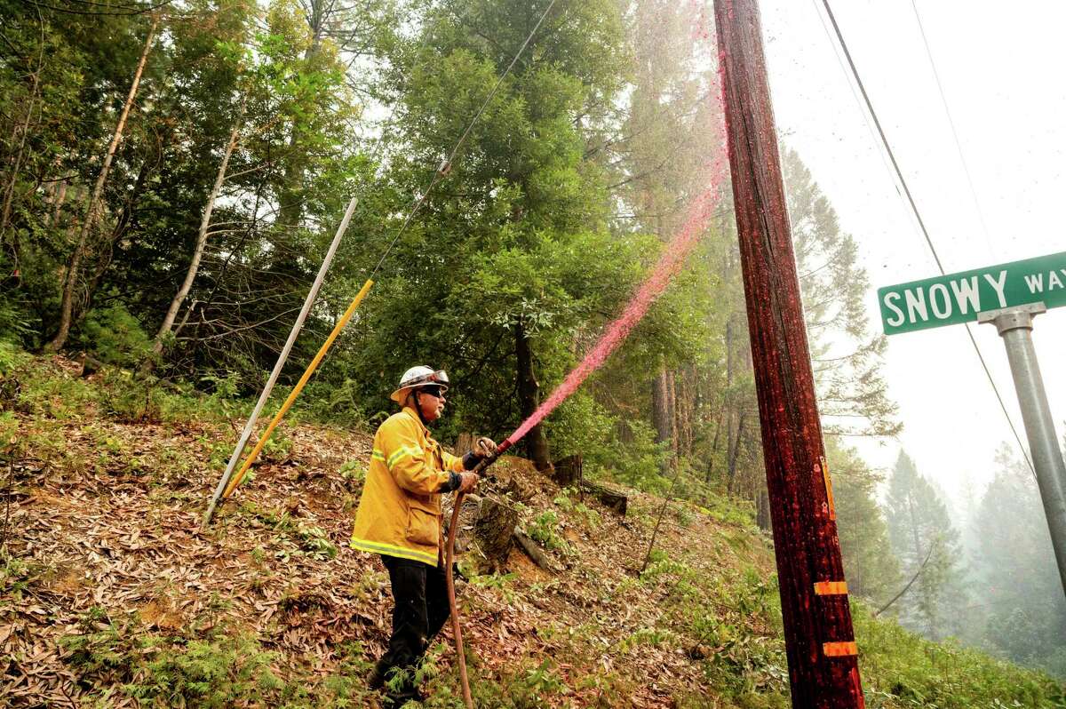 9月，在埃尔多拉多县的火山维尔附近，一名太平洋燃气电力消防队员在电线杆上喷洒阻燃剂，以保护基础设施。PG&E表示正在努力加强安全。