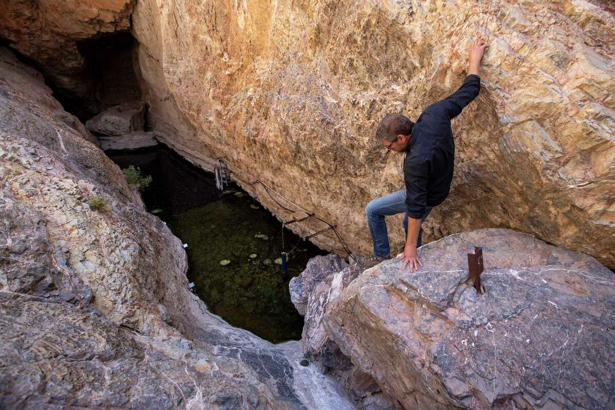 U.S. Fish and Wildlife Service senior fish biologist Michael Schwimm climbs down into Devils Hole on April 29, 2022, in Nevada's Ash Meadows National Wildlife Refuge.