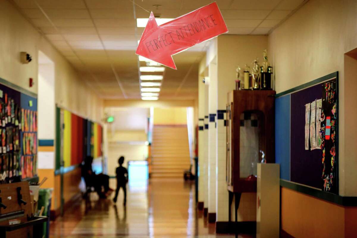 A sign pointing to a perfect attendance board can be seen in the hallway at Cesar Chavez Elementary School in San Francisco, Calif. on Tuesday, Sept. 20, 2022. Almost a quarter of students in San Francisco Unified school district missed 18 or more school days in 2021-22, so far higher than the national average for chronic absence.