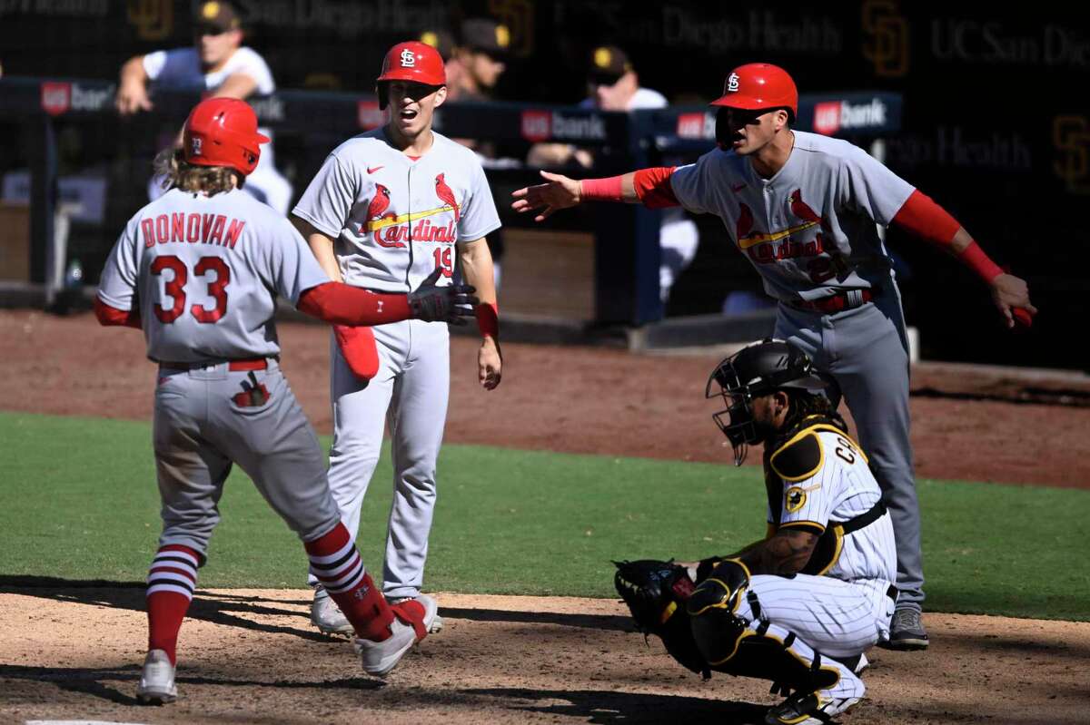 St. Louis Cardinals' Brendan Donovan, left, is congratulated by Tommy Edman, center, and Lars Nootbaar after hitting a grand slam during the seventh inning of the team's baseball game against the San Diego Padres, Thursday, Sept. 22, 2022, in San Diego. (AP Photo/Denis Poroy)