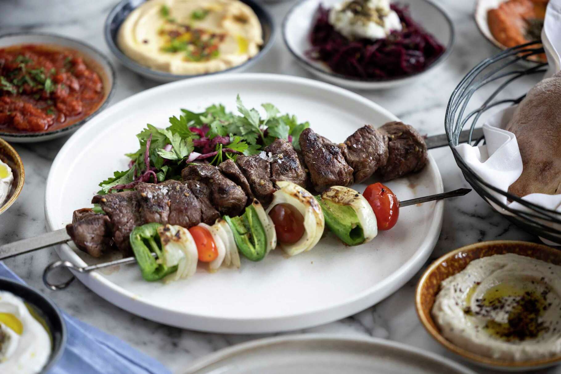 Lamb & beef kabob with grilled tomato, tahini and jalapeños at Hamsa.