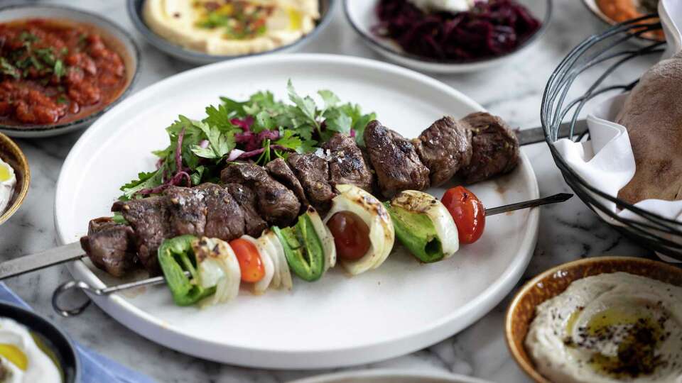 Lamb & beef kabob with grilled tomato, tahini and jalapeños at Hamsa.