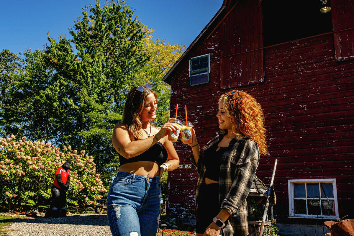 Olivia of Bristol and Alyssa of Southington enjoy a drink of hard cider at Hogan's Cider Mill in Burlington, Connecticut, on September 21, 2022.