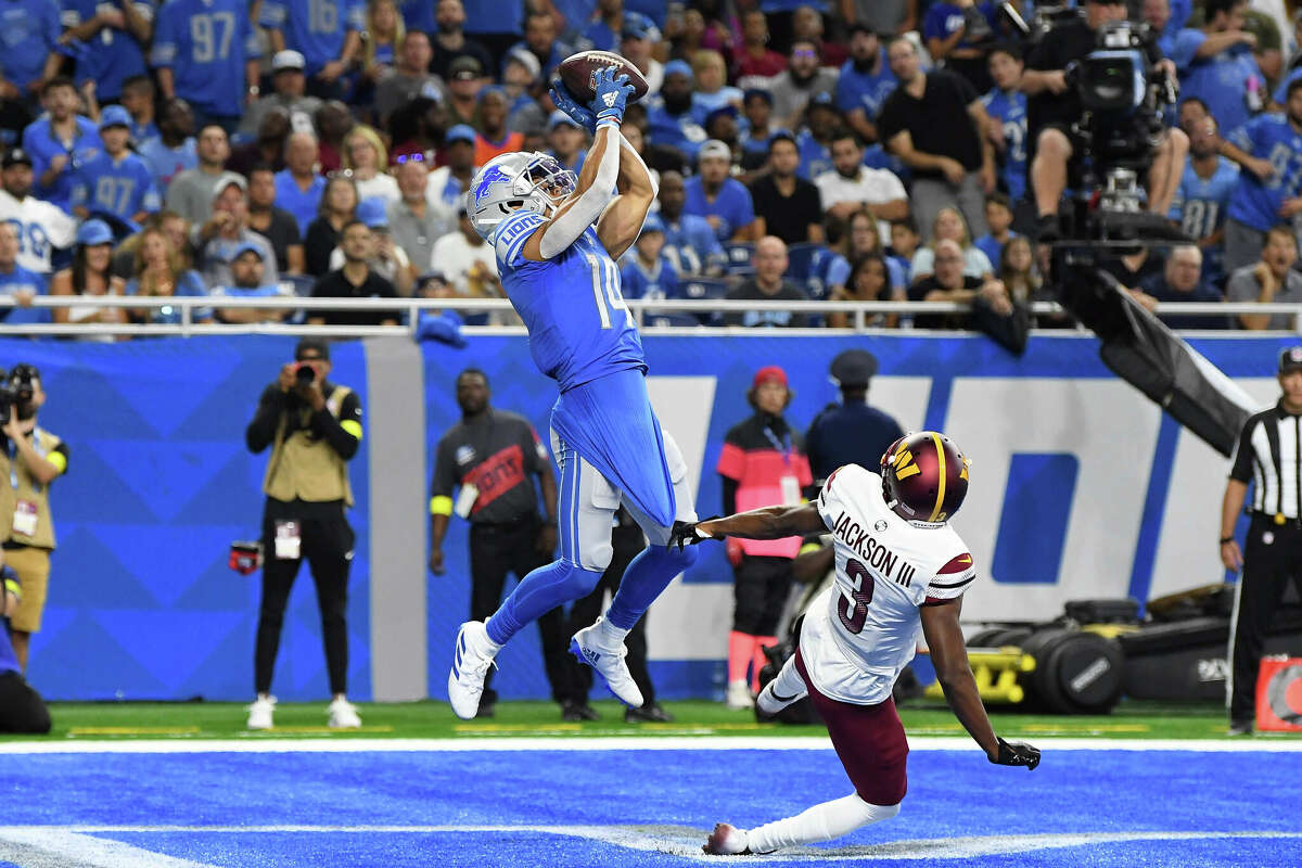 Detroit Lions wide receiver Amon-Ra St. Brown (14) makes a touchdown catch against Washington Commanders cornerback William Jackson III (3) during the first half of an NFL football game Sunday, Sept. 18, 2022, in Detroit. (AP Photo/Lon Horwedel)
