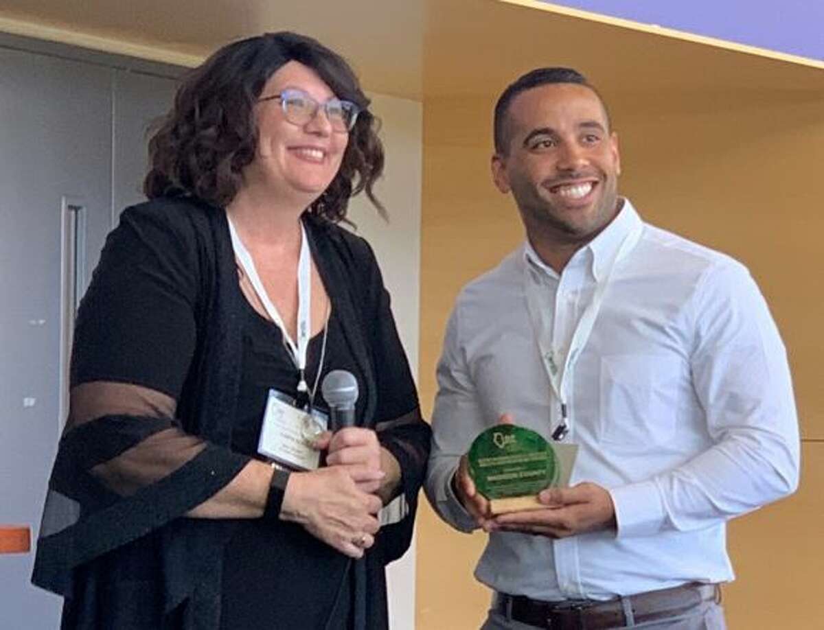 Madison County Resource Management Coordinator Brandon Banks, right, accepts an “Outstanding Public Sector Recycling Program” award from Illinois Recycling Foundation President Marta Keane during the group's annual conference in August in Joliet.