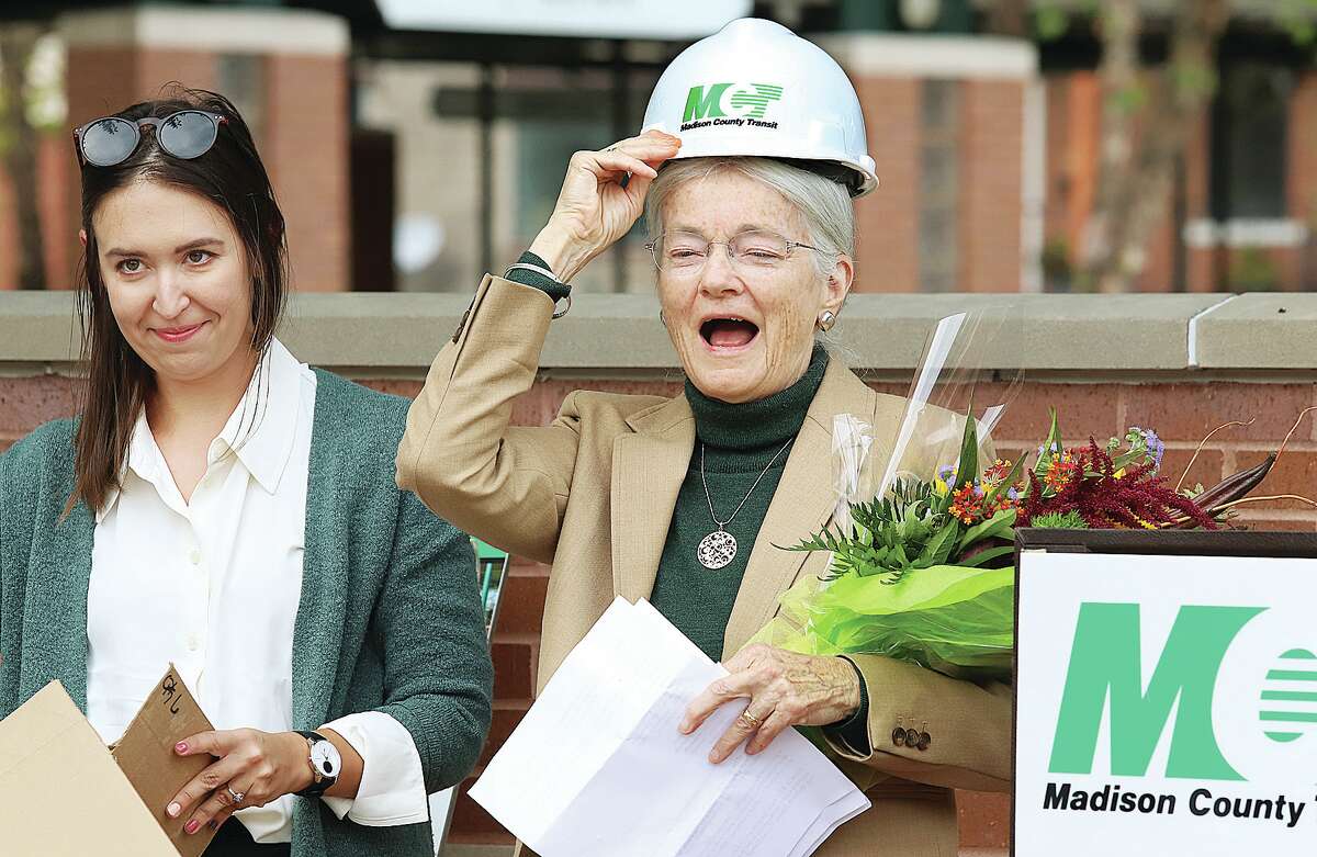John Badman|The Telegraph Anna Haine laughs after being presented with an MCT hard hat Thursday at the dedication of a plaza at 6th and Piasa streets named the Senator Bill and Anna Haine Plaza. The plaza is part of the MCT bus station in downtown Alton.