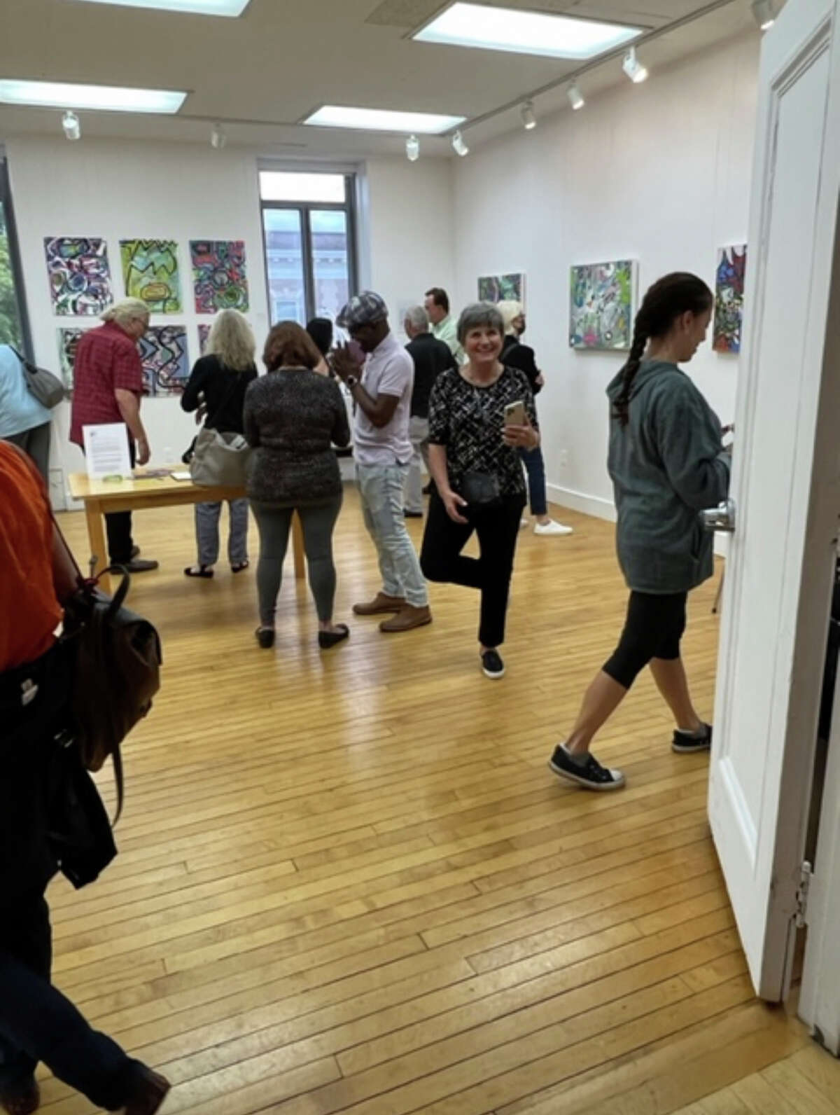 The crowd mingles at the recent opening reception fora called "Time in Place" at the Greenwich Art Society featuring the work of artist Lina Moriell. It will be on view through Sept. 30.