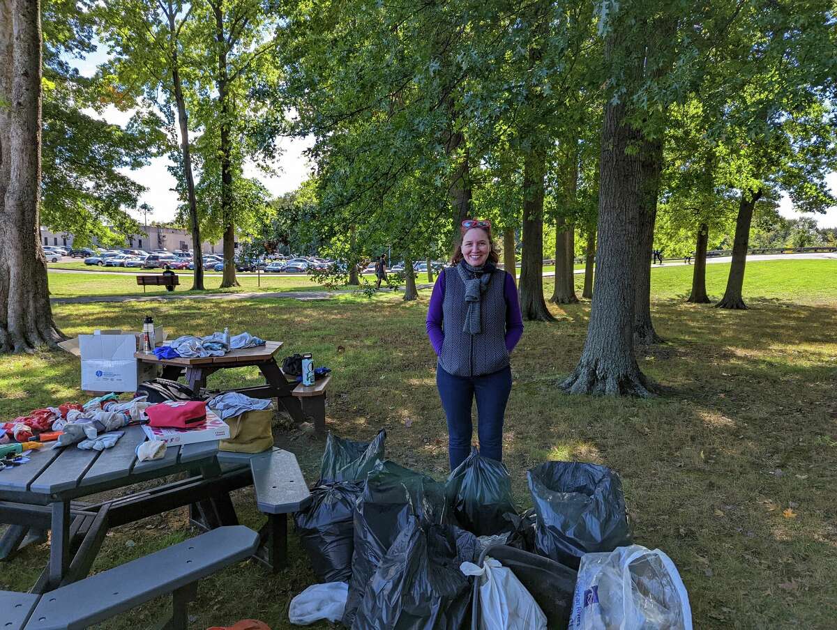 Plastic pollution expert professor Katherine Owens poses behind several bags of trash collected by student volunteers and her on the University of Hartford campus as part of the Source to Sea Cleanup event on September 23, 2022. 