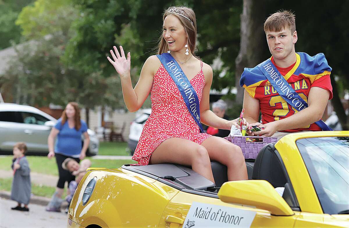 John Badman|The Telegraph Lily Daugherty and Jackson Harris, two of several homecoming maids and men of honor, wave at the large crowd Thursday night during the Roxana Homecoming Parade.