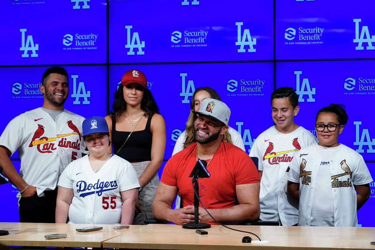 St. Louis Cardinals designated hitter Albert Pujols, center, is surrounded by his family while speaking to reporters after a baseball game against the Los Angeles Dodgers in Los Angeles, Friday, Sept. 23, 2022. Pujols hit his 700th home run during the fourth inning.
