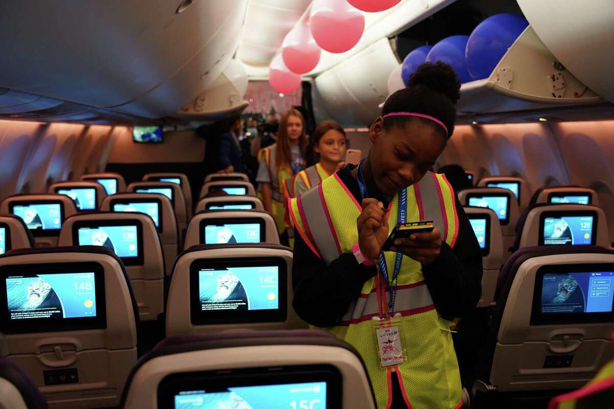 Aboard a parked 737 MAX airplane, Mariah Leonard, 11, practices taking beverage orders as though she were a flight attendant. United Airlines showcased a variety of aviation-related careers to more than 30 middle and high school students during Girls in Aviation Day at Intercontinental Airport on September 24, 2022 in Houston, Texas.