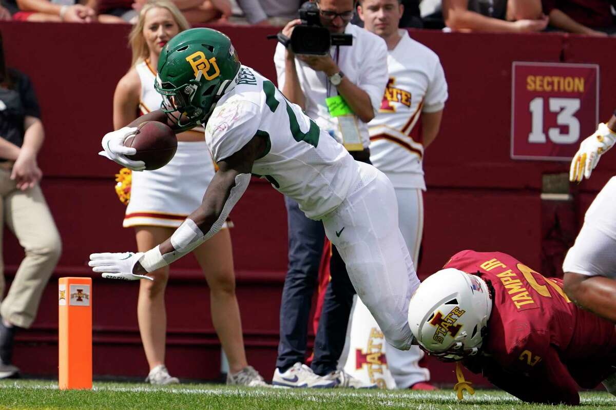 Baylor running back Richard Reese (29) scores on a 19-yard touchdown run ahead of Iowa State defensive back T.J. Tampa (2) during the second half of an NCAA college football game, Saturday, Sept. 24, 2022, in Ames, Iowa. Baylor won 31-24.