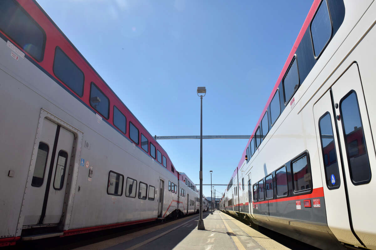 An older model Caltrain, left, stands idle in front of the newly unveiled electric train, right, at the Fourth and King station, in San Francisco, on Saturday.  24 September 2022. 