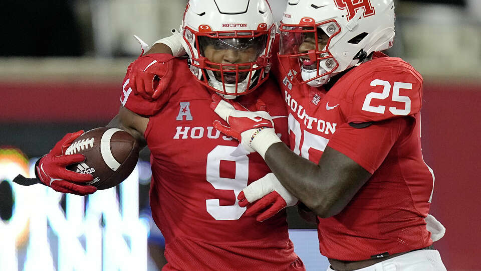 Houston Cougars defensive lineman Nelson Ceaser (9) is congratulated by Jamal Morris (25) after returning a fumble recovery for a touchdown to take the lead in the fourth quarter of a football game against the Rice Owls Saturday, Sept. 24, 2022, in Houston.