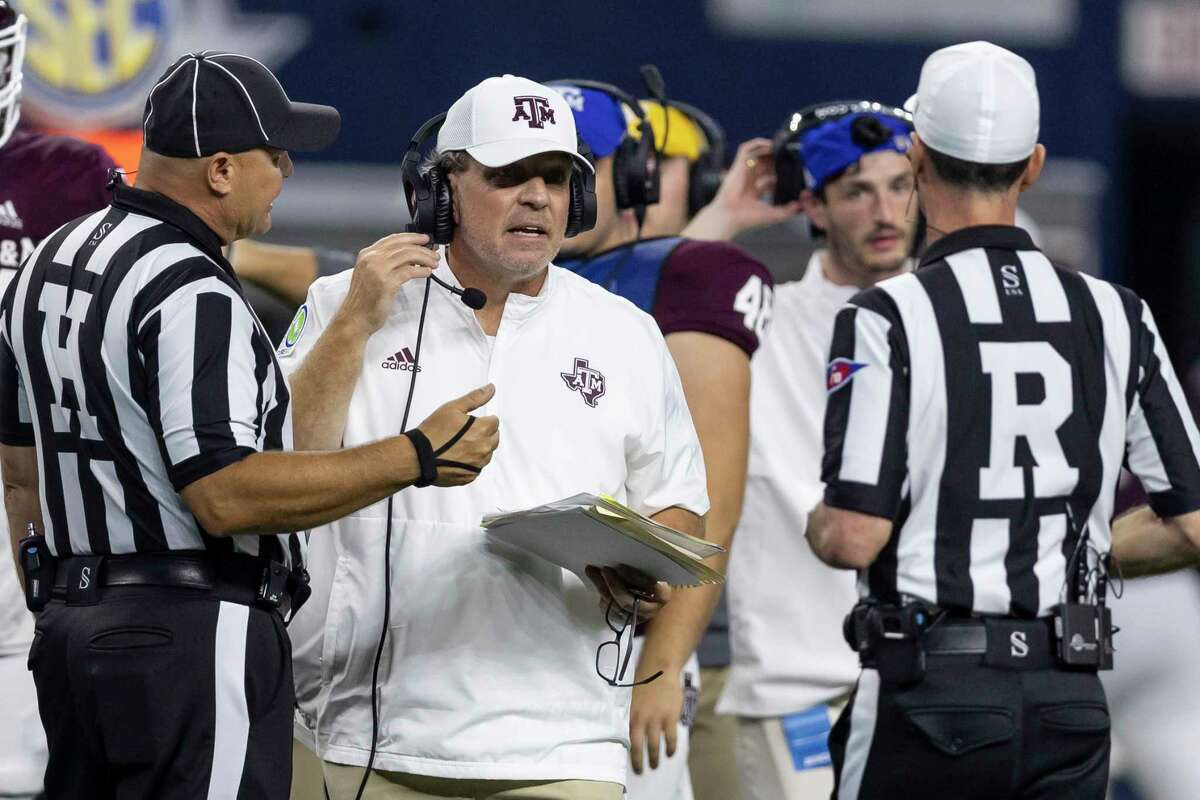 Texas A&M coach Jimbo Fisher confers with head line judge Chad Green, left, and referee Ken Williamson during the second half of the team's NCAA college football game against Arkansas on Saturday, Sept. 24, 2022, in Arlington, Texas. Texas A&M won 23-21.