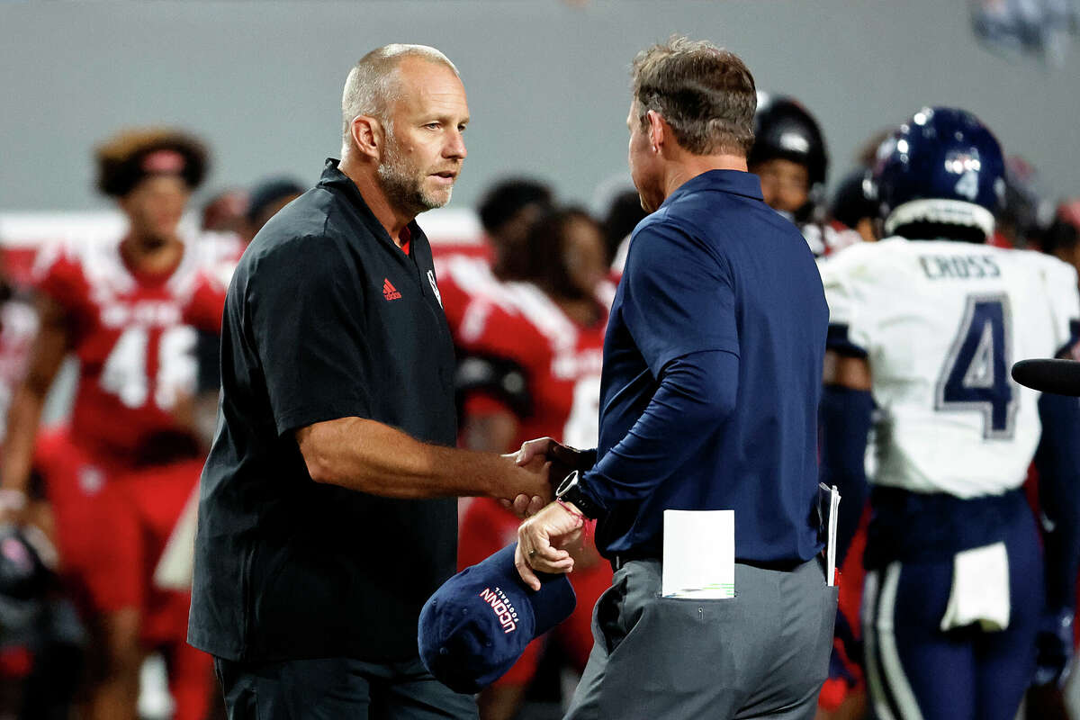 North Carolina State head coach Dave Doeren, left, speaks with Connecticut head coach Jim L. Mora following an NCAA college football game in Raleigh, N.C., Saturday, Sept. 24, 2022. (AP Photo/Karl B DeBlaker)