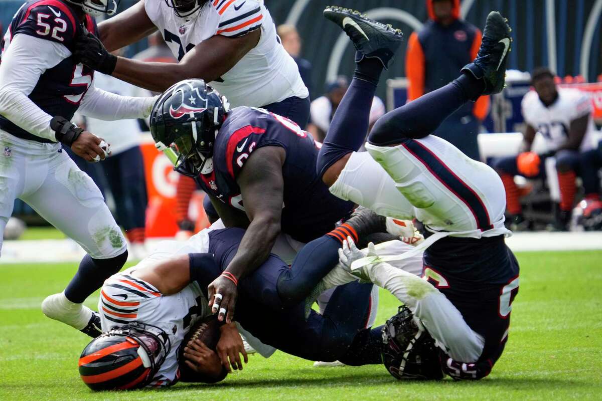 Houston Texans defensive linemen Maliek Collins (96) and Jerry Hughes (55) sack Chicago Bears quarterback Justin Fields (1) during the first half of an NFL football game Sunday, Sept. 25, 2022, in Chicago.