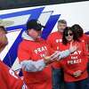 Tommy Finn, of Stamford, leads a group prayer with other Pray for Peace supporters at the Noroton Heights train station in Darien on Sunday. About 30 people took a bus to Grand Central, where they trekked up to Yankee Stadium to attend the Yankees game donning red Pray for Peace shirts.
