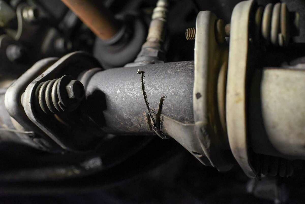 Todd Goulding points out where a catalytic converter was cut off in a Honda Accord that had the part almost stolen in San Francisco, Calif. on Aug. 17, 2022.